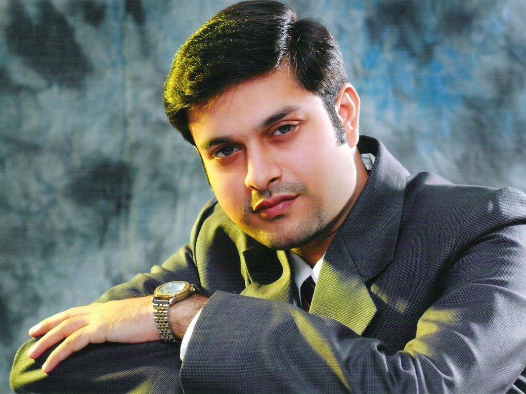 Dr. Anand Vyas (Dr. V) in a suit, posing for a portrait.
